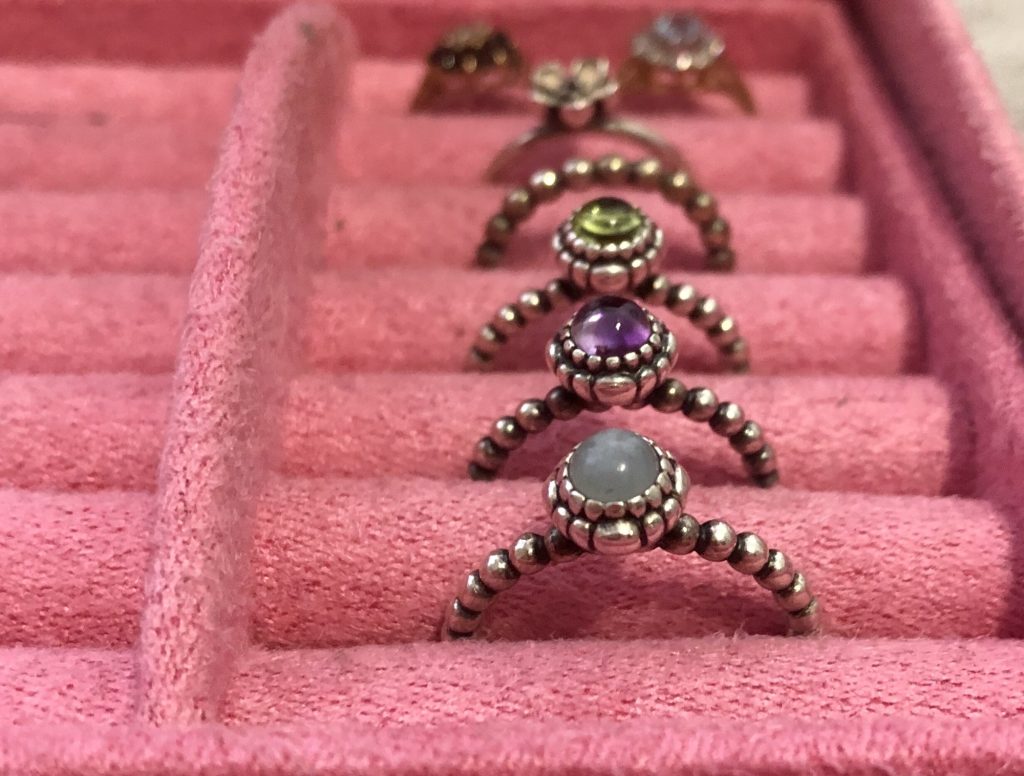 A row of rings in a pink jewellery box